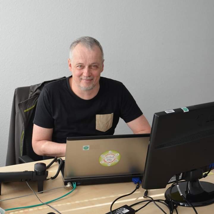 Foto von Joachim Fischer sitzend beim Arbeiten an seinem Computer